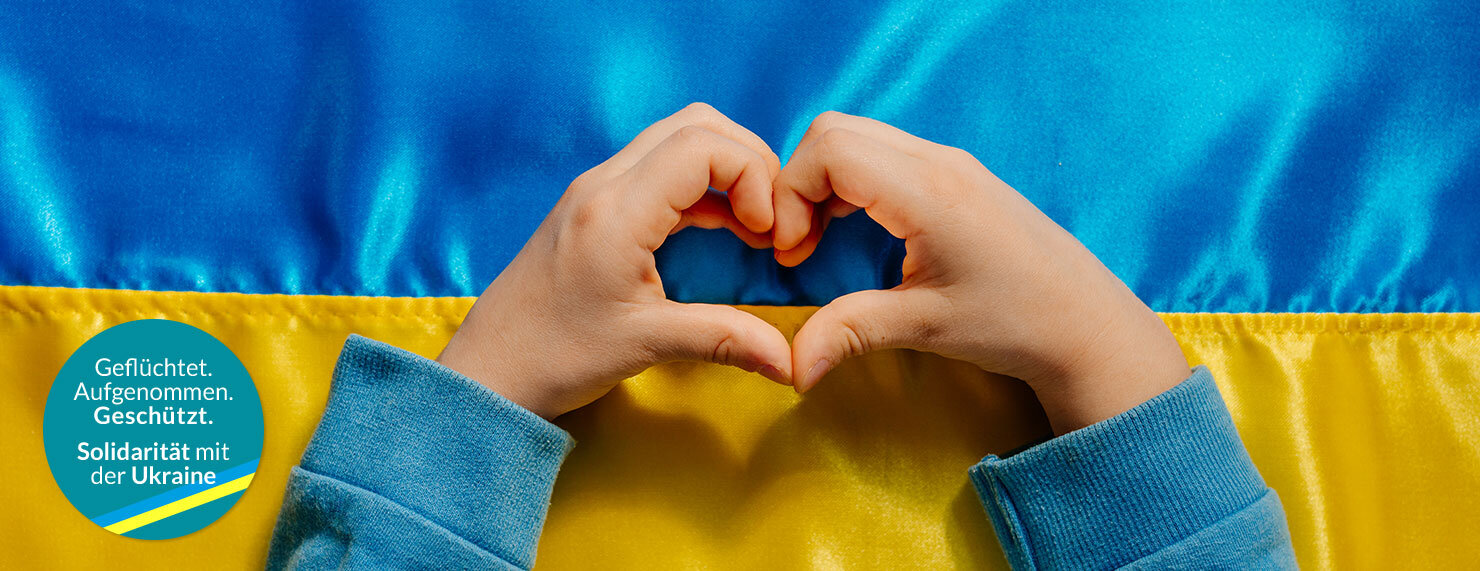 Ukraine Flagge mit Kinderhänden die ein Herz formen