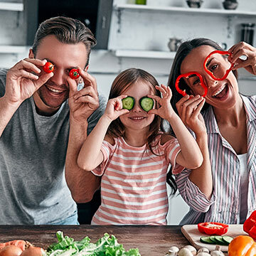 IDEAL Risikoleben: Junge Familie macht Spaß in der Küche