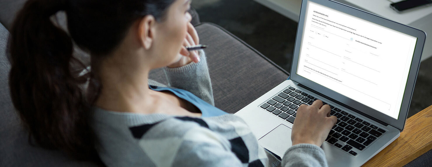 Frau füllt am Laptop Onlineformular aus