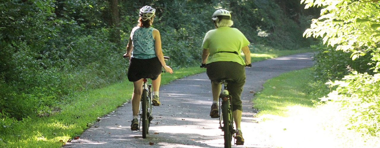 Zwei ältere Damen Fahren mit dem Fahrrad auf einem Schotterweg