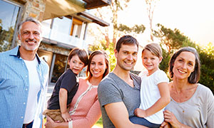 Familie gemeinsam hinter einem Haus