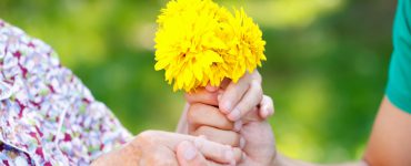 Demenz - Hände, die Blumen umschließen