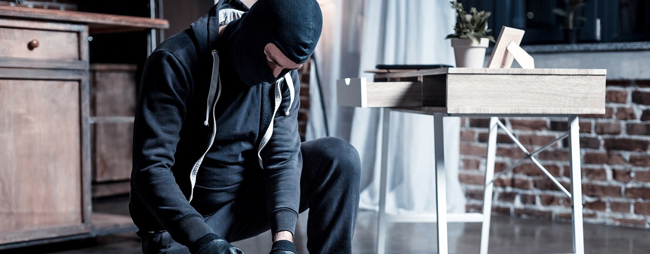 Maskierter Einbrecher durchsucht den Hausrat