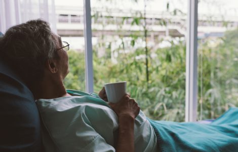 Senior schaut aus dem Fenster
