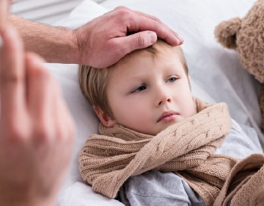 Vater kümmert sich um seinen kranken Sohn im Bett