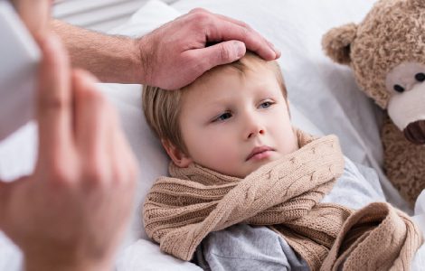 Vater kümmert sich um seinen kranken Sohn im Bett