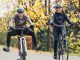 Zwei Personen fahren mit einem E-Bike oder Pedelec einen Waldweg entlang