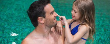 Vater spielt mit seiner Tochter im Schwimmbad