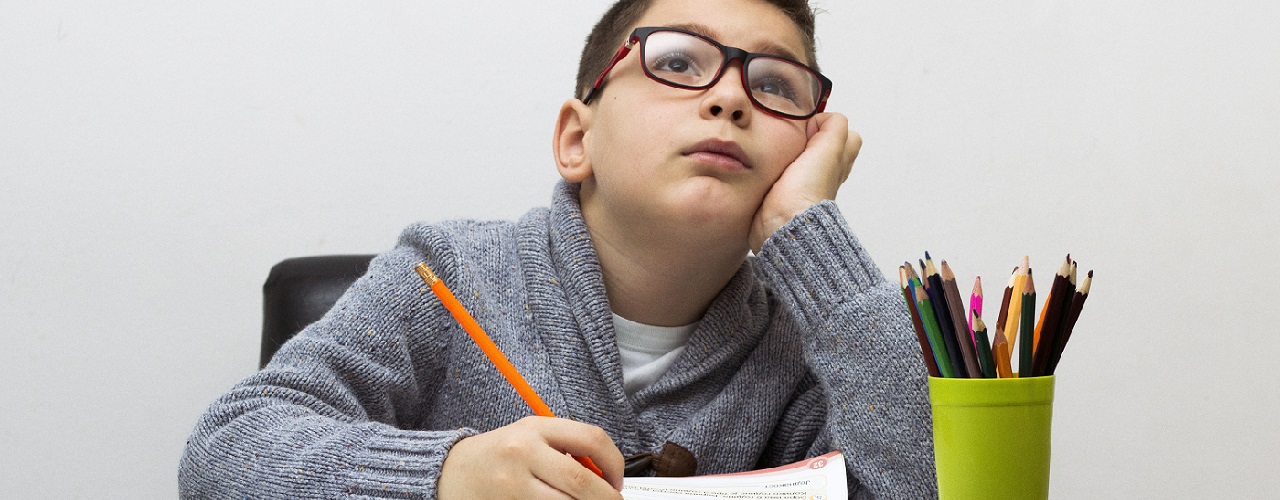 Junge sitzt demotiviert am Tisch