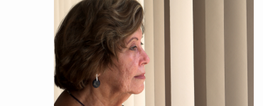 Ältere Frau schaut aus dem Fenster