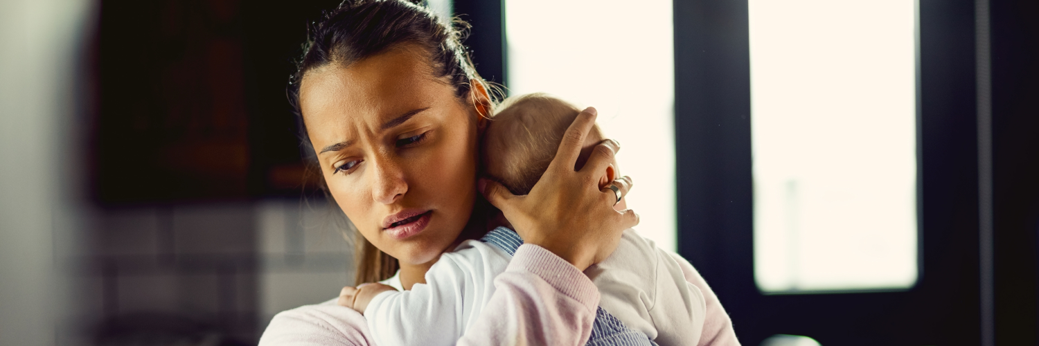 Eine junge Mutter mit einem Baby auf dem Arm