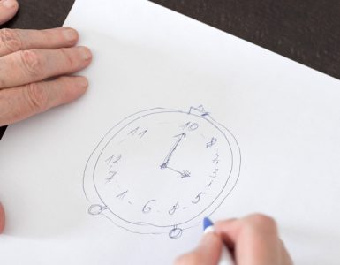Eine Nahaufnahme von einem DIN A4 Blatt, auf dem Eine Uhr gezeichnet wurde