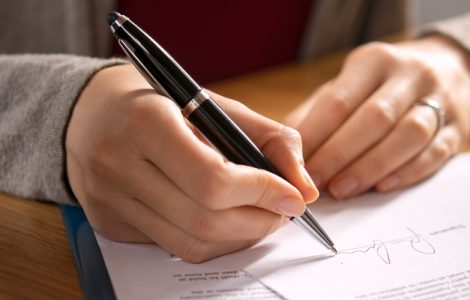Person unterschreibt ein Dokument