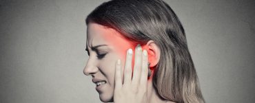 Frau mit Ohrenschmerzen und Tinnitus