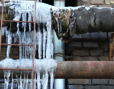 Eine geplatzte Wasserleitung. Das ausgetretene Wasser ist gefroren.