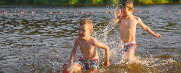 Zwei kleine Jungen spielen in einem See
