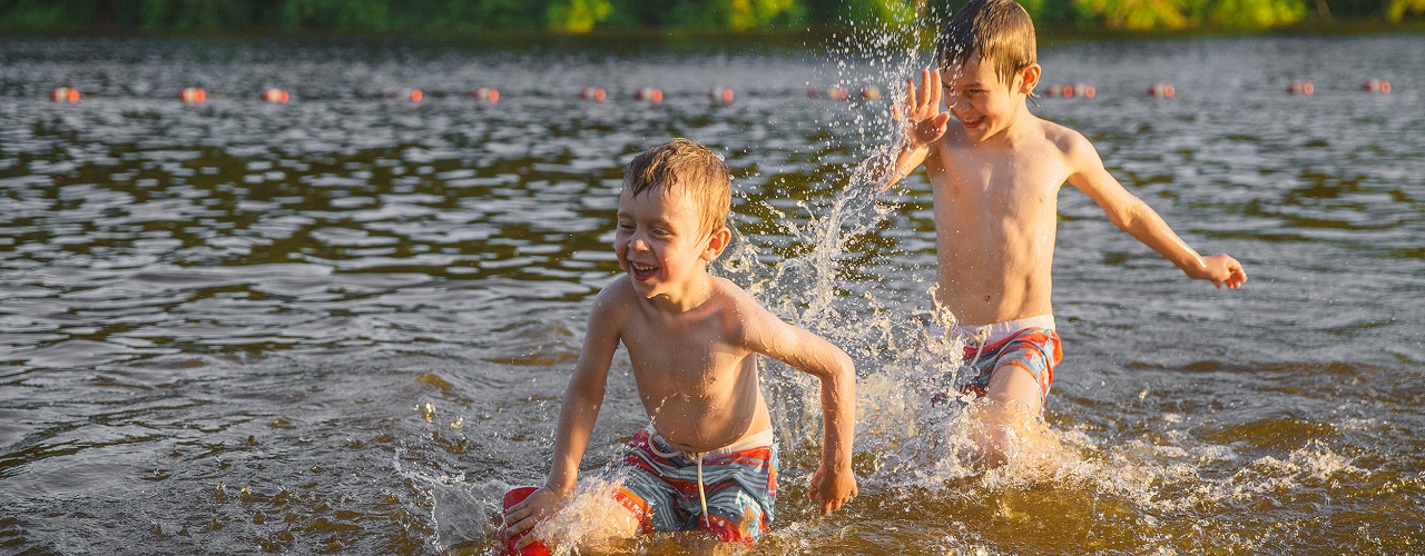 Zwei kleine Jungen spielen in einem See