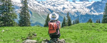 Frau sitzt auf Stein in den Bergen