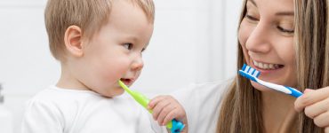 Kleiner Junge lernt mit seiner Mama das Zähneputzen