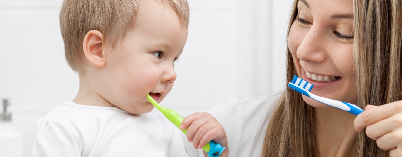 Kleiner Junge lernt mit seiner Mama das Zähneputzen