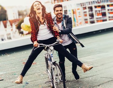 IDEAL Unfallversicherung: Frau und Mann lachend auf dem Fahrrad